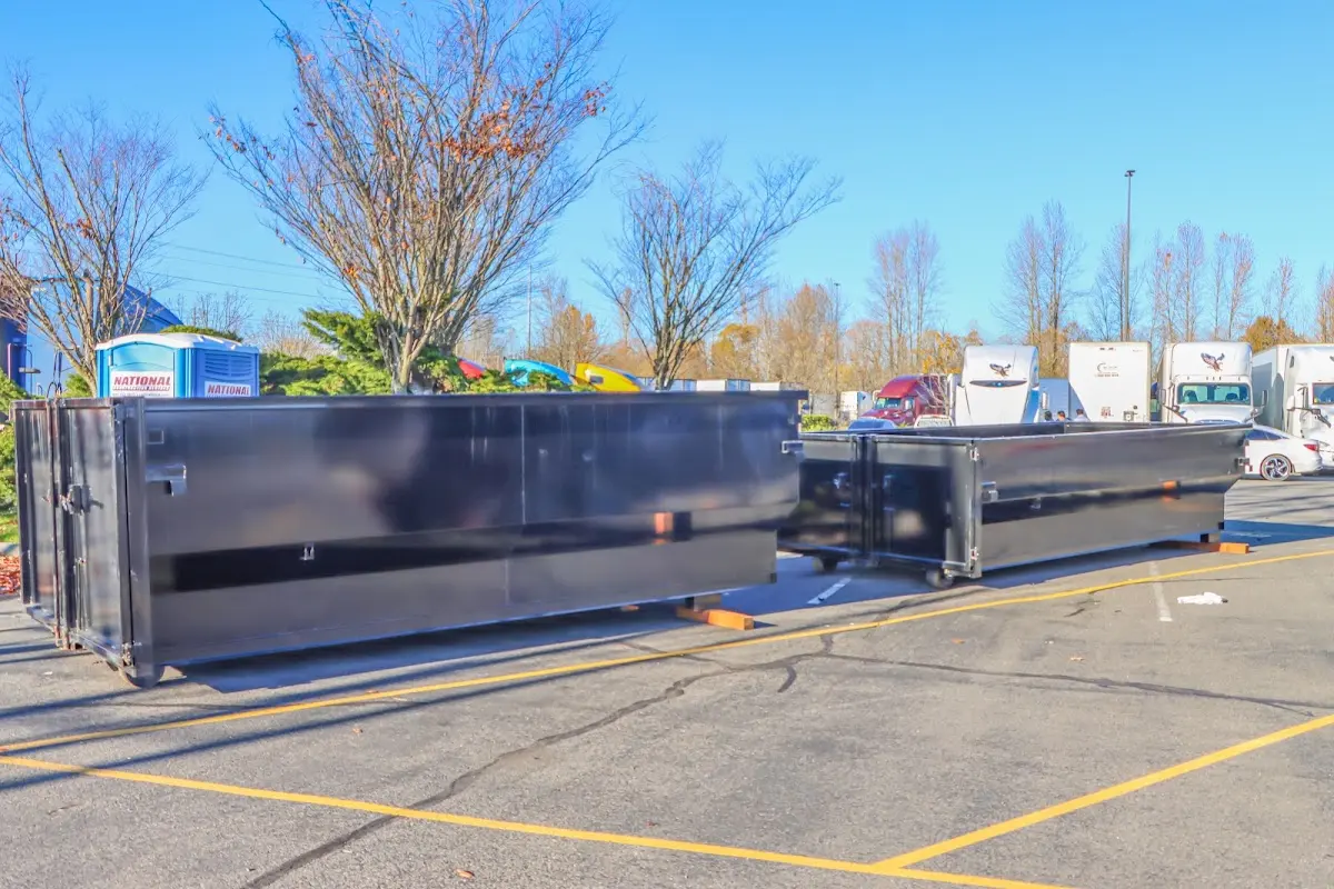 Professional dumpster rental service with roll-off container on residential driveway in Wellesley